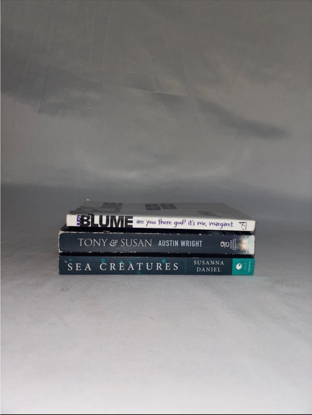 Stack of Three Books - Blue, Black, White Covers